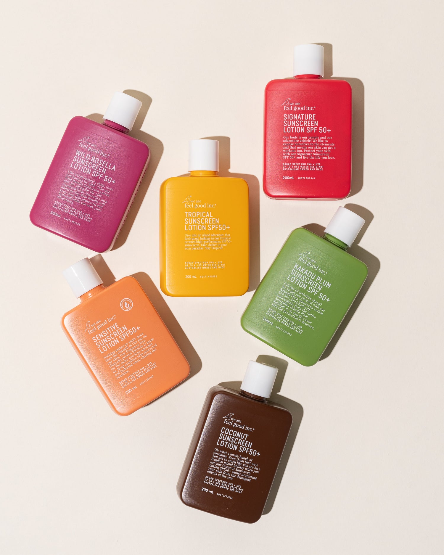 A colourful collection of We Are Feel Good Inc. sunscreens and body lotions in various shades on a yellow background