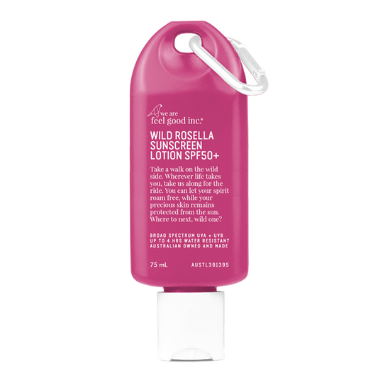 A fuchsia-coloured 75ml bottle of 'We Are Feel Good Inc. Wild Rosella Sunscreen Lotion SPF50+' with a white cap and loop for easy carrying