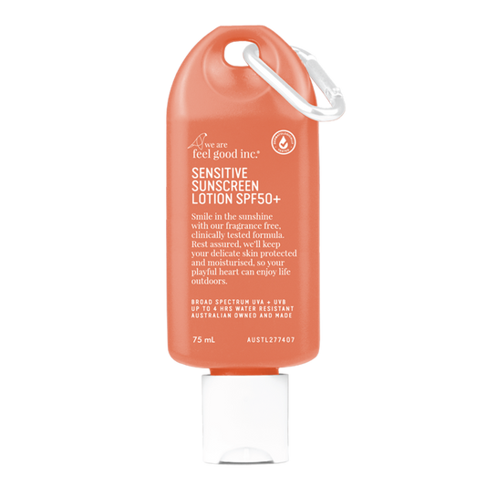 A peach-coloured 75ml bottle of 'We Are Feel Good Inc. Sensitive Sunscreen Lotion SPF50+' with a white cap and loop for easy carrying